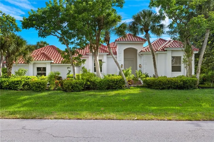 Mediterranean / spanish house with stucco siding, a front lawn, and a tile roof