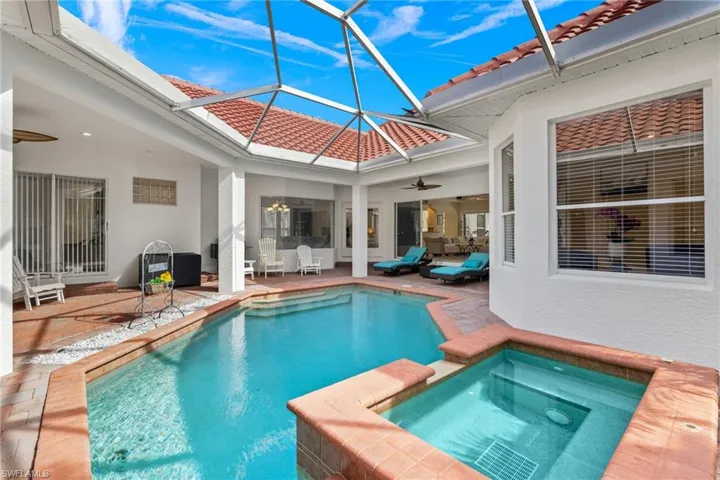 View of pool featuring a ceiling fan, a lanai, a patio, a sunroom, and a pool with connected hot tub