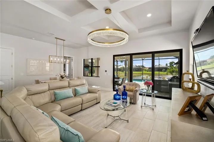 Living room featuring coffered ceiling and a notable chandelier