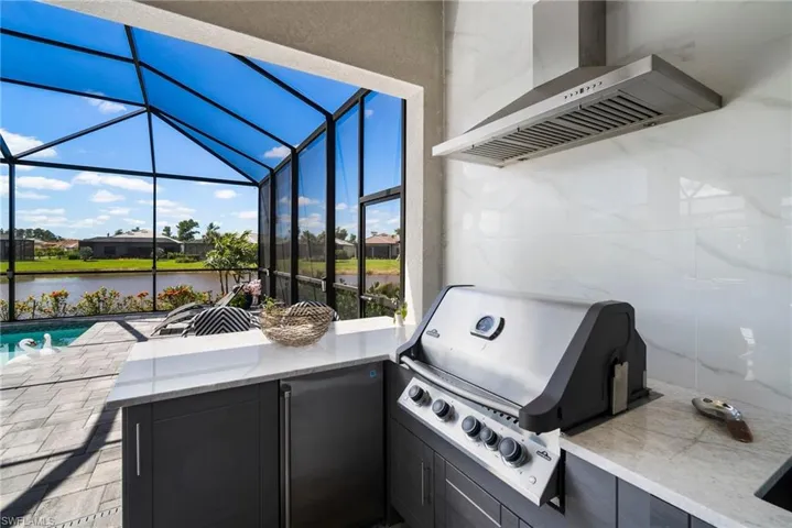 View of patio / terrace with a water view, grilling area, and glass enclosure