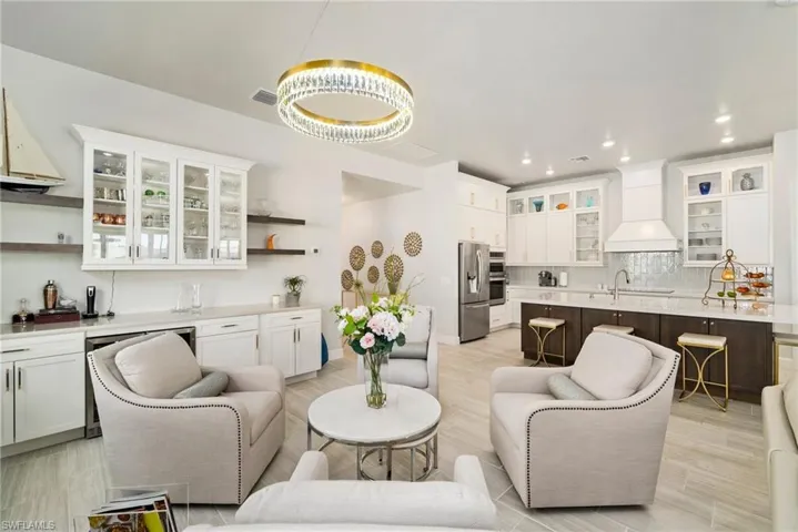 Living room with bar area and light wood-type flooring