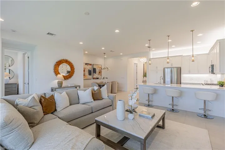 Living room with a notable chandelier, sink, and light tile floors