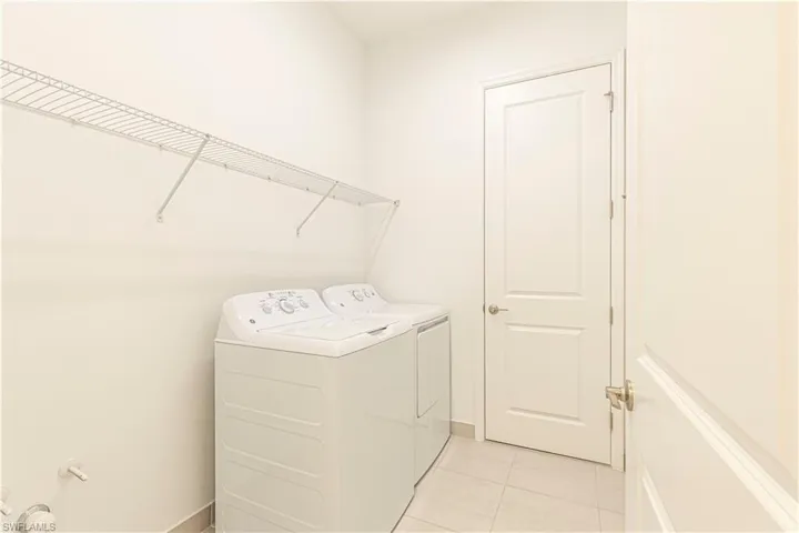 Laundry area featuring independent washer and dryer and light tile floors