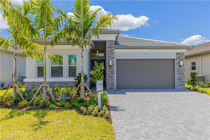View of front of home with a front lawn, a garage, and central AC unit