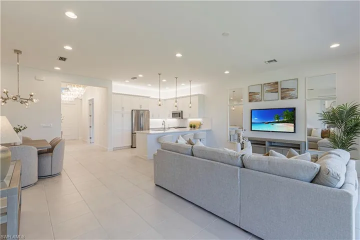 Living room with sink, light tile floors, and a chandelier