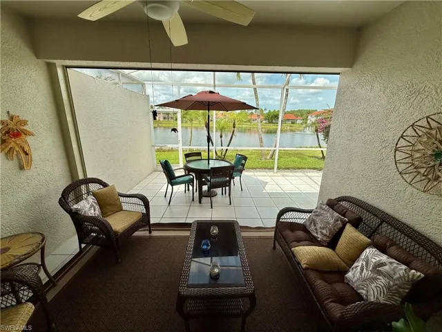 Sunroom / solarium with a water view, a ceiling fan, and outdoor dining space