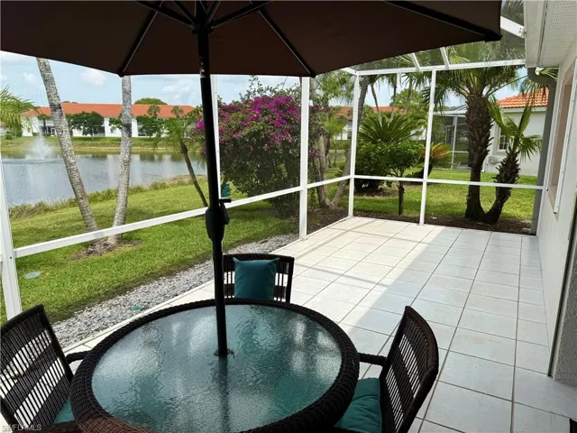 Unfurnished sunroom with a water view and outdoor dining space