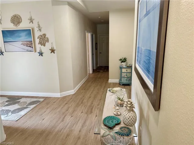 Corridor with light wood-style floors and baseboards