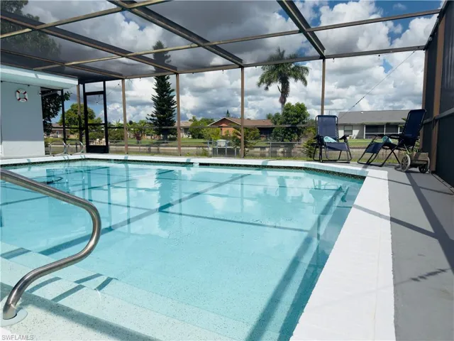 Swimming pool featuring a sunroom, a lanai, and a patio