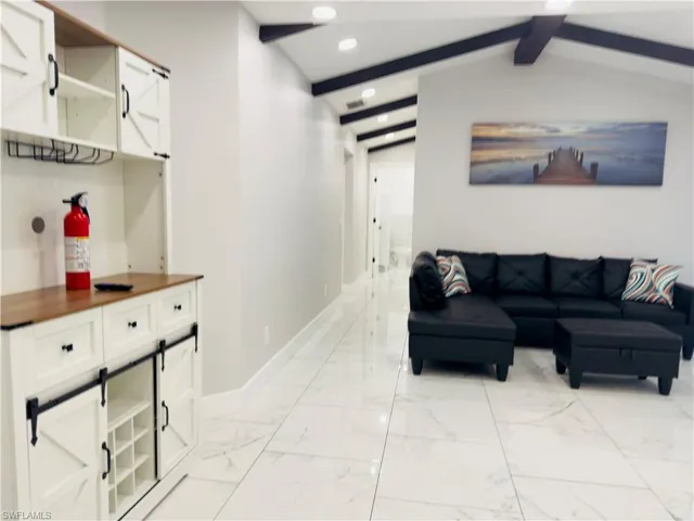 Living area with recessed lighting and light marble finish floors