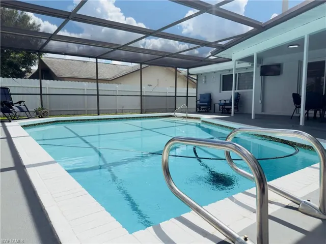 View of pool featuring glass enclosure, a patio area, and a sunroom