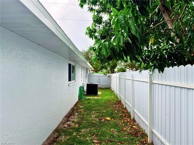 View of side of home with a fenced backyard and stucco siding