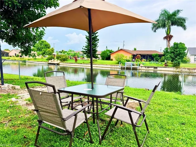 View of property's community with a patio, a water view, and outdoor dining area