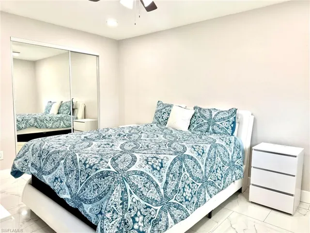 Bedroom featuring light marble finish flooring, a ceiling fan, a closet, and recessed lighting