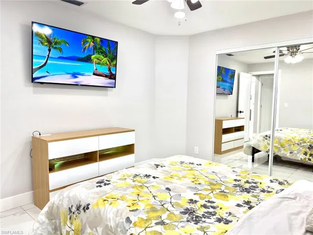 Bedroom with light tile patterned floors and a ceiling fan