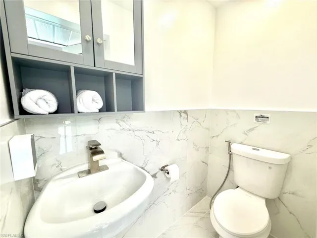 Half bath with a sink and marble finish flooring