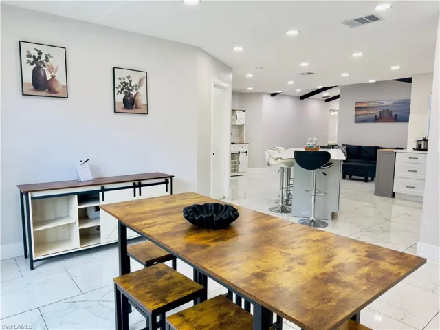 Dining area with light marble finish flooring and recessed lighting