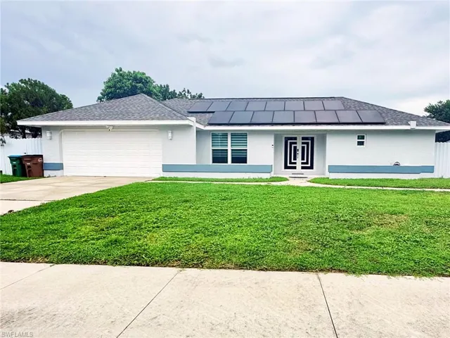 Single story home featuring a front yard, stucco siding, concrete driveway, and a garage