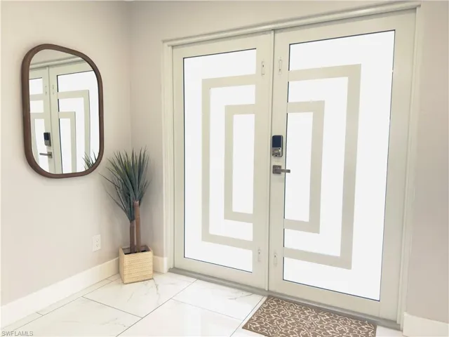 Doorway with marble look tile flooring and french doors