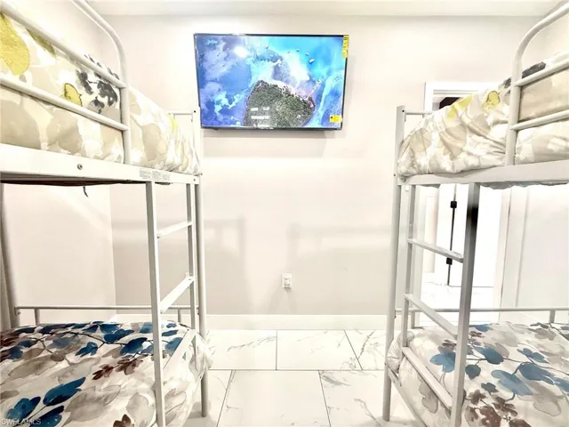 Bedroom with light marble finish flooring and baseboards