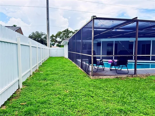 Fenced backyard featuring glass enclosure and a sunroom