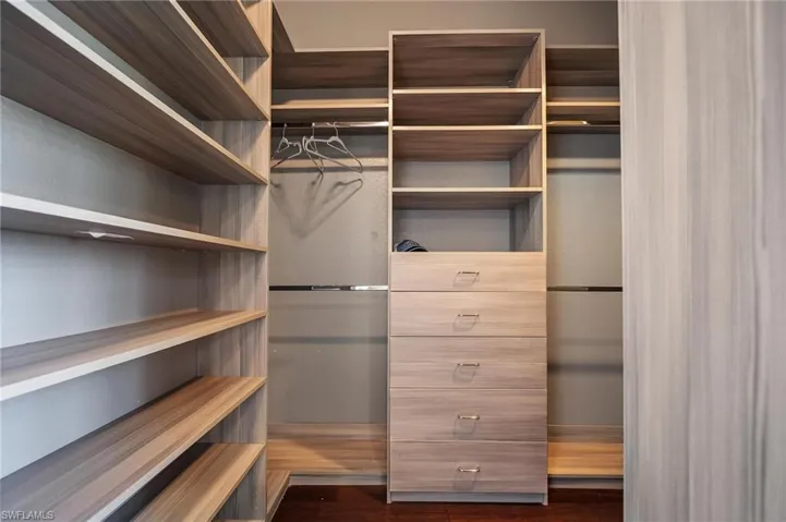 Spacious closet with dark wood-style floors