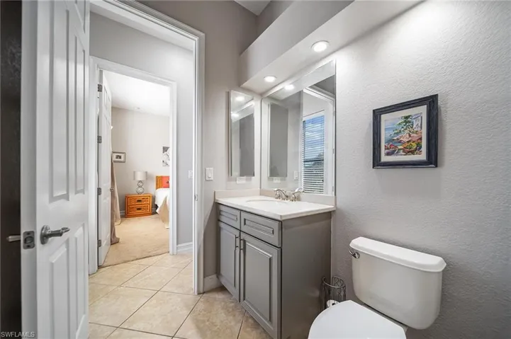 Bathroom featuring tile patterned floors, toilet, connected bathroom, and vanity