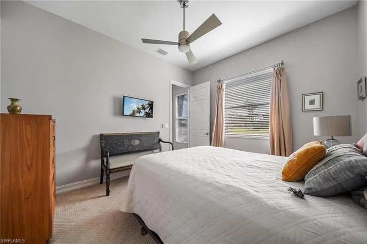 Carpeted bedroom featuring visible vents, ceiling fan, and baseboards