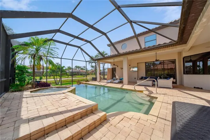 View of swimming pool featuring a lanai, a patio area, an outdoor living space, and a pool with connected hot tub