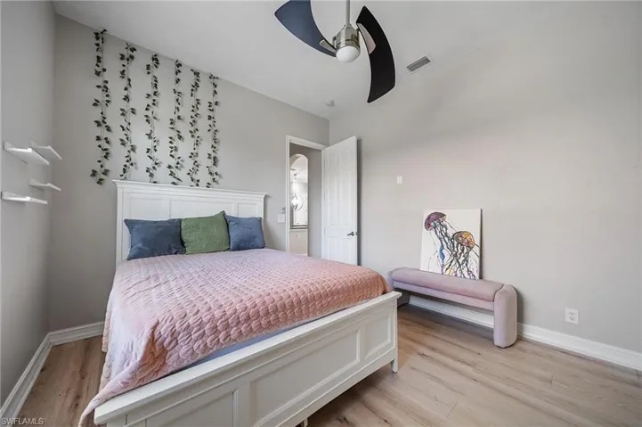 Bedroom with baseboards, visible vents, a ceiling fan, and light wood-style floors