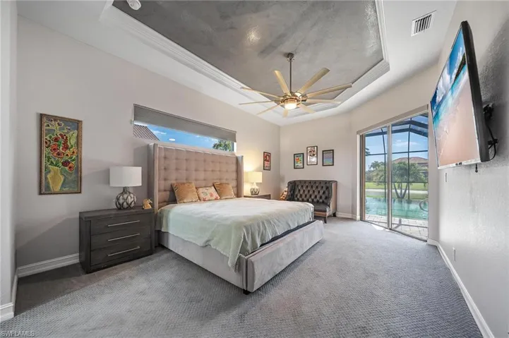 Bedroom featuring visible vents, a raised ceiling, access to outside, and carpet flooring