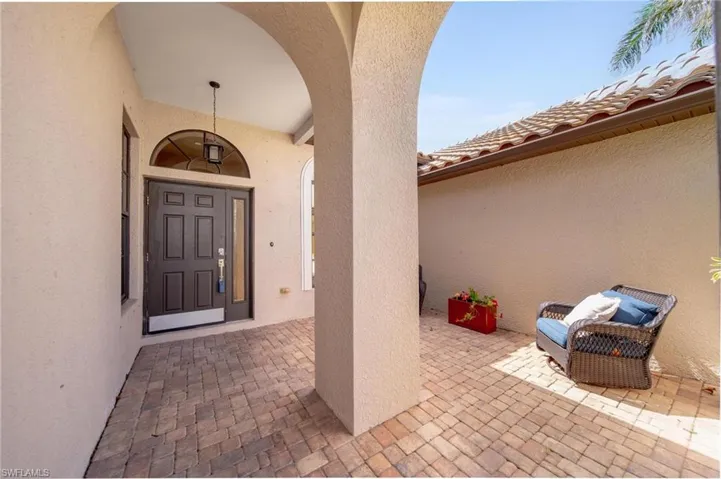 Doorway to property featuring stucco siding and a patio