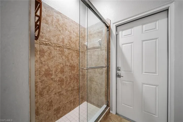 Full bath with tile patterned flooring and a stall shower