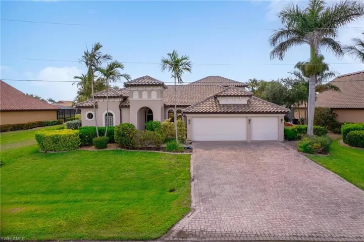 Mediterranean / spanish-style house with stucco siding, a tiled roof, decorative driveway, a garage, and a front yard