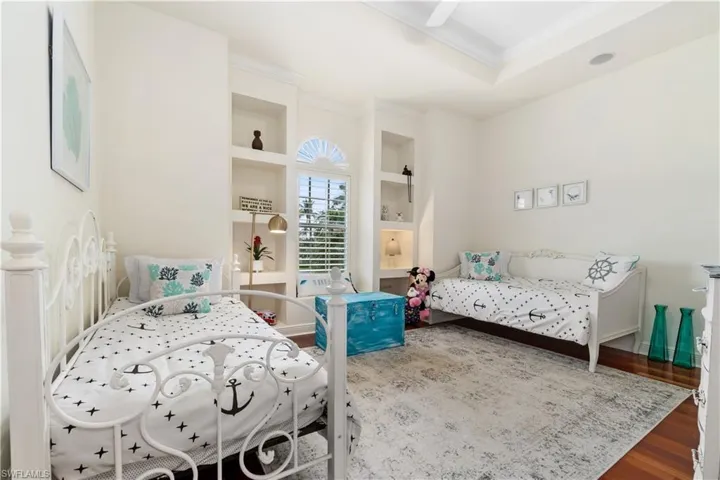 Bedroom featuring crown molding, wood finished floors, and ceiling fan