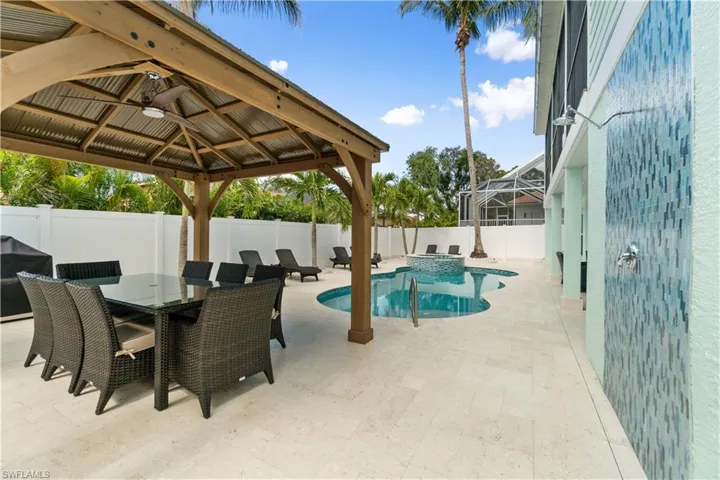 Integrated pool / spa with a patio, a gazebo, outdoor dining area, area for grilling, and a fenced backyard