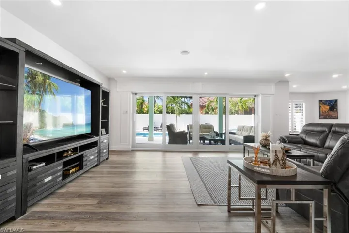 Living room with light wood finished floors, healthy amount of natural light, and recessed lighting