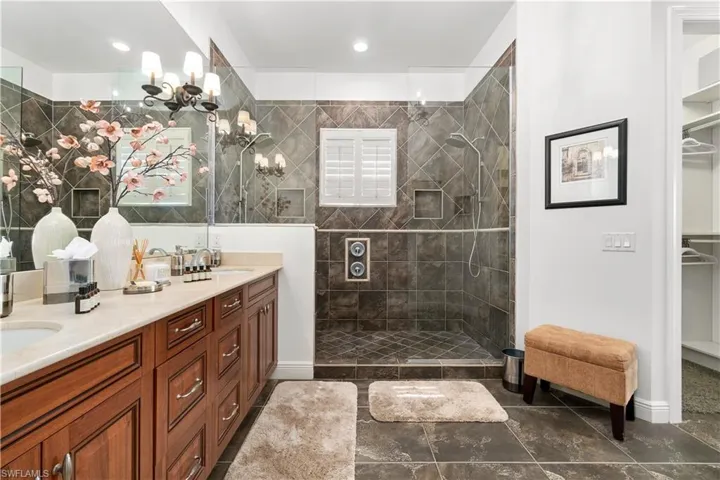 Bathroom featuring double vanity, a walk in closet, and walk in shower