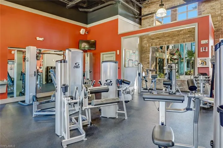Workout area featuring brick wall and a high ceiling