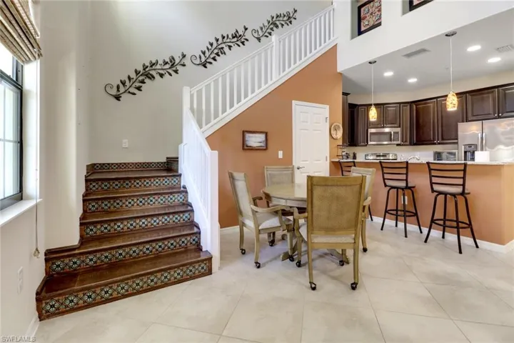 Dining room featuring recessed lighting, stairs, and a high ceiling