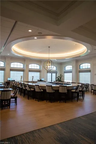 Dining room featuring a raised ceiling, plenty of natural light, and hardwood / wood-style floors