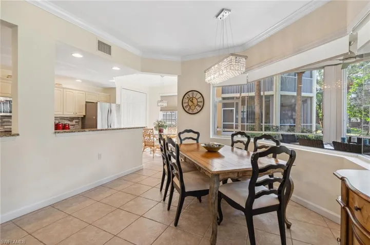 Dining area featuring crown molding, light tile patterned flooring, and a chandelier