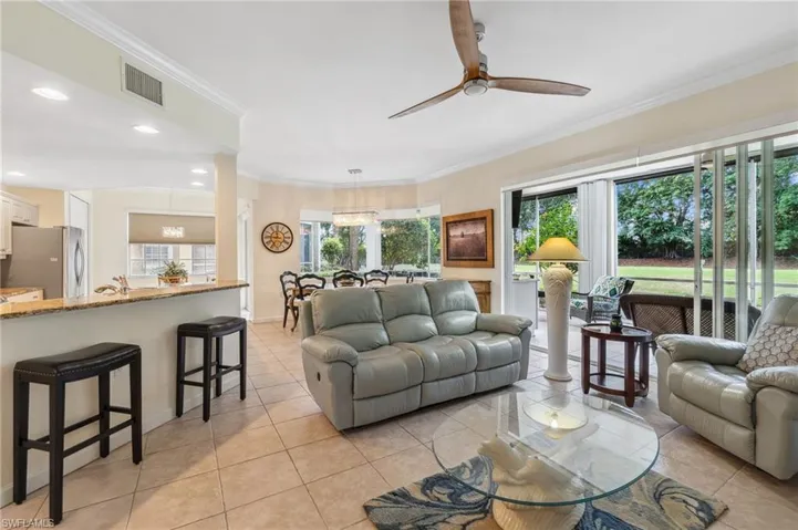 Tiled living room with crown molding and ceiling fan
