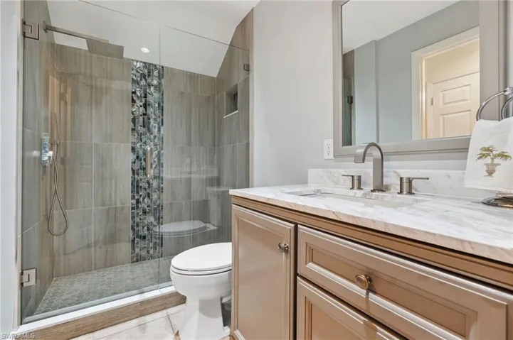 Bathroom featuring tile patterned floors, a shower with curtain, vanity, and toilet