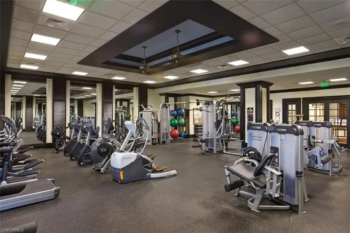 Exercise room featuring a raised ceiling and a drop ceiling