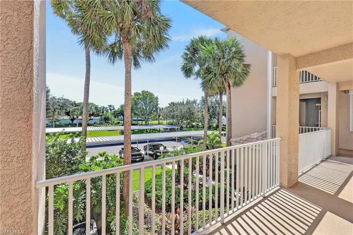 The balcony overlooks the parking lot and the manicured landscaping