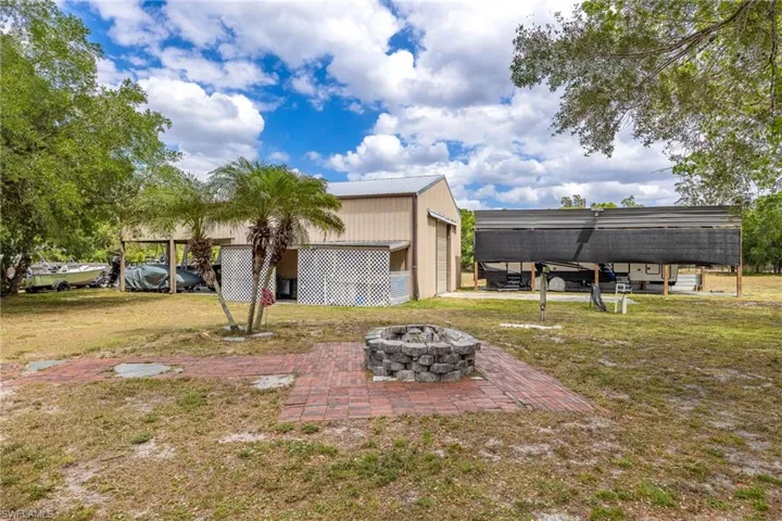View of yard featuring an outdoor fire pit and an outbuilding