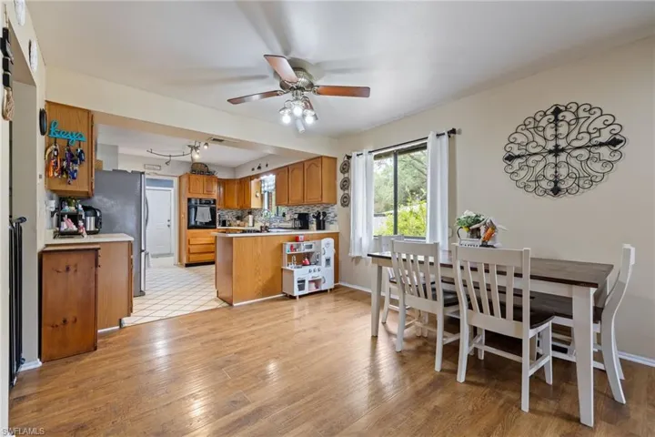 Dining space with a ceiling fan, baseboards, and light wood finished floors