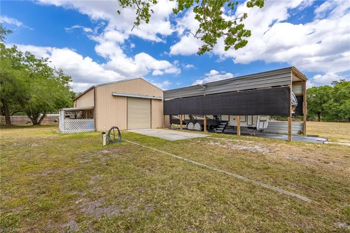 View of pole building featuring driveway and a yard