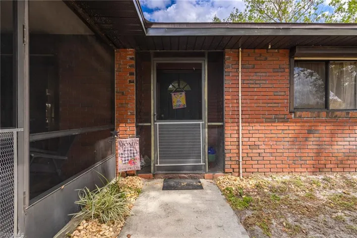 Doorway to property featuring brick siding